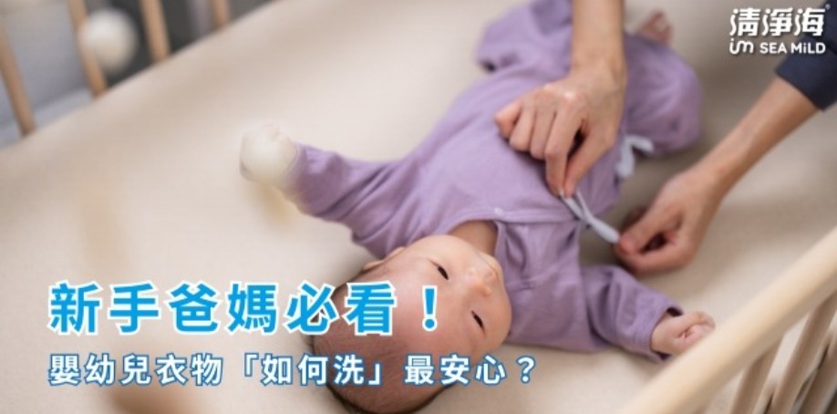 在白色嬰兒床上，躺著一位穿著紫色包屁衣的嬰兒，嬤嬤正在幫嬰兒穿上衣服