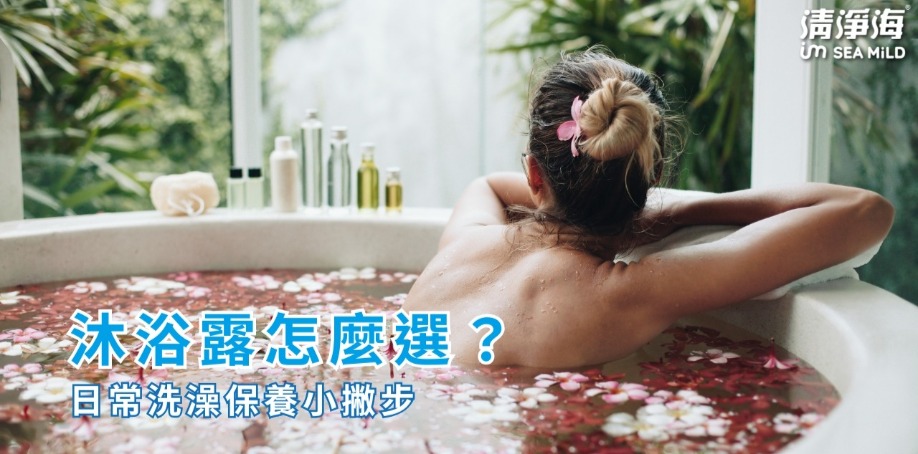 白色浴缸裡放滿水，水面上鋪滿粉白色花瓣，一名女人在浴缸內泡著，女人左邊擺放著七瓶瓶子與白色沐浴球