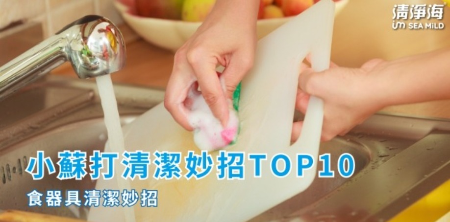 小蘇打清潔妙招TOP10食器具清潔妙招 廚房流理台上打開水龍頭,左手拿著白色塑膠沾板,右手拿著塗抹清潔劑的綠色菜瓜布,正在清潔沾板上的黃色污漬