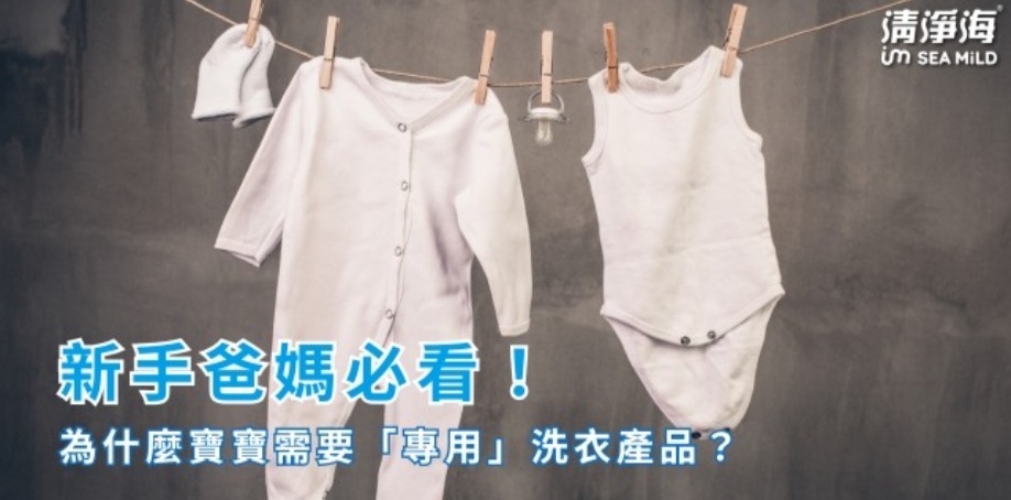 一條曬衣繩上掛著嬰兒的白色襪子、白色包屁衣服與白色尿布